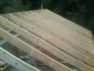 New roof rafters set over an addition before sheathing in New York Mills