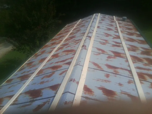 Rusted metal roof panels with new wood purlins before replacement — Storm Damage Roof Repair in New York Mills by Roofing Brothers